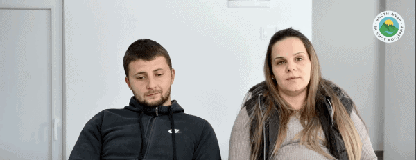 Мушкарац и жена седе у просторији, видљив лого у углу