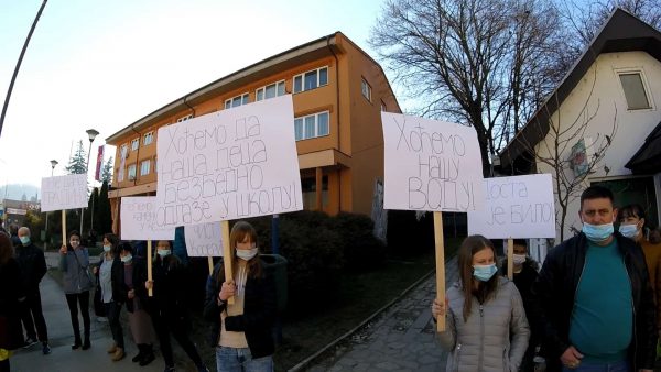 Протестанти са транспарентима испред школе, носе маске