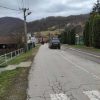 Сеоски пут са црним теренцем и кућама у позадини