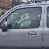 Човек седи у сивом аутомобилу, поглед кроз прозор
