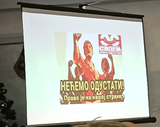 Пројекција плаката „НЕЋЕМО ОДУСТАТИ!“ са логом Слога